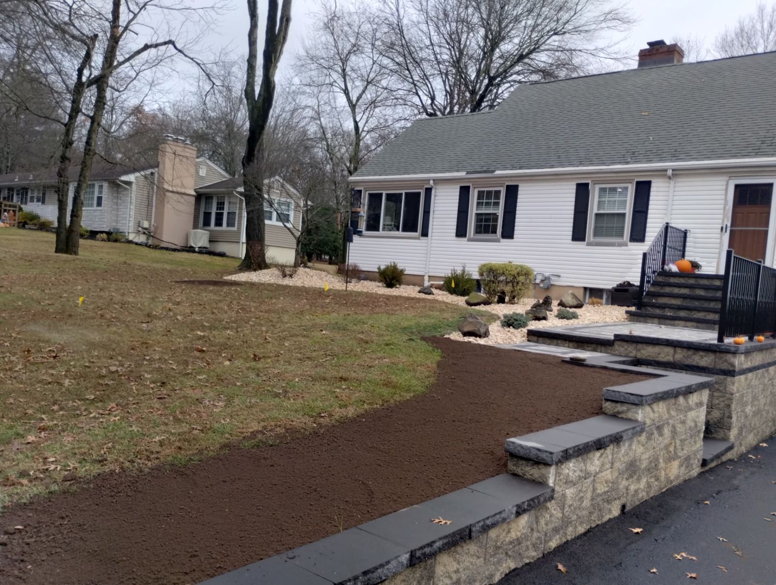 Front yard hardscape build with paver landing, steps and river rock beds in New Jersey