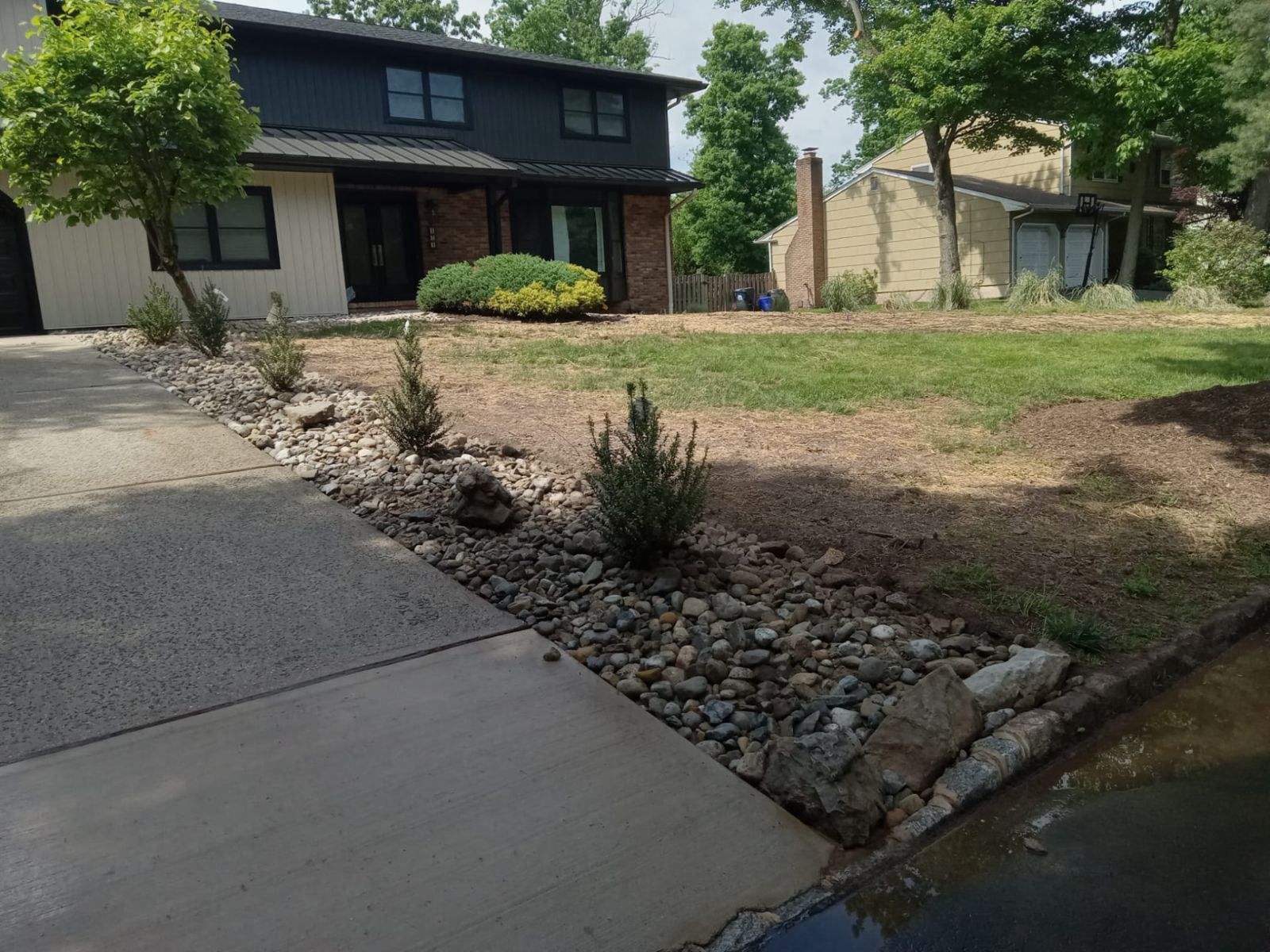 Front yard hardscape build with paver landing, steps and river rock beds in New Jersey