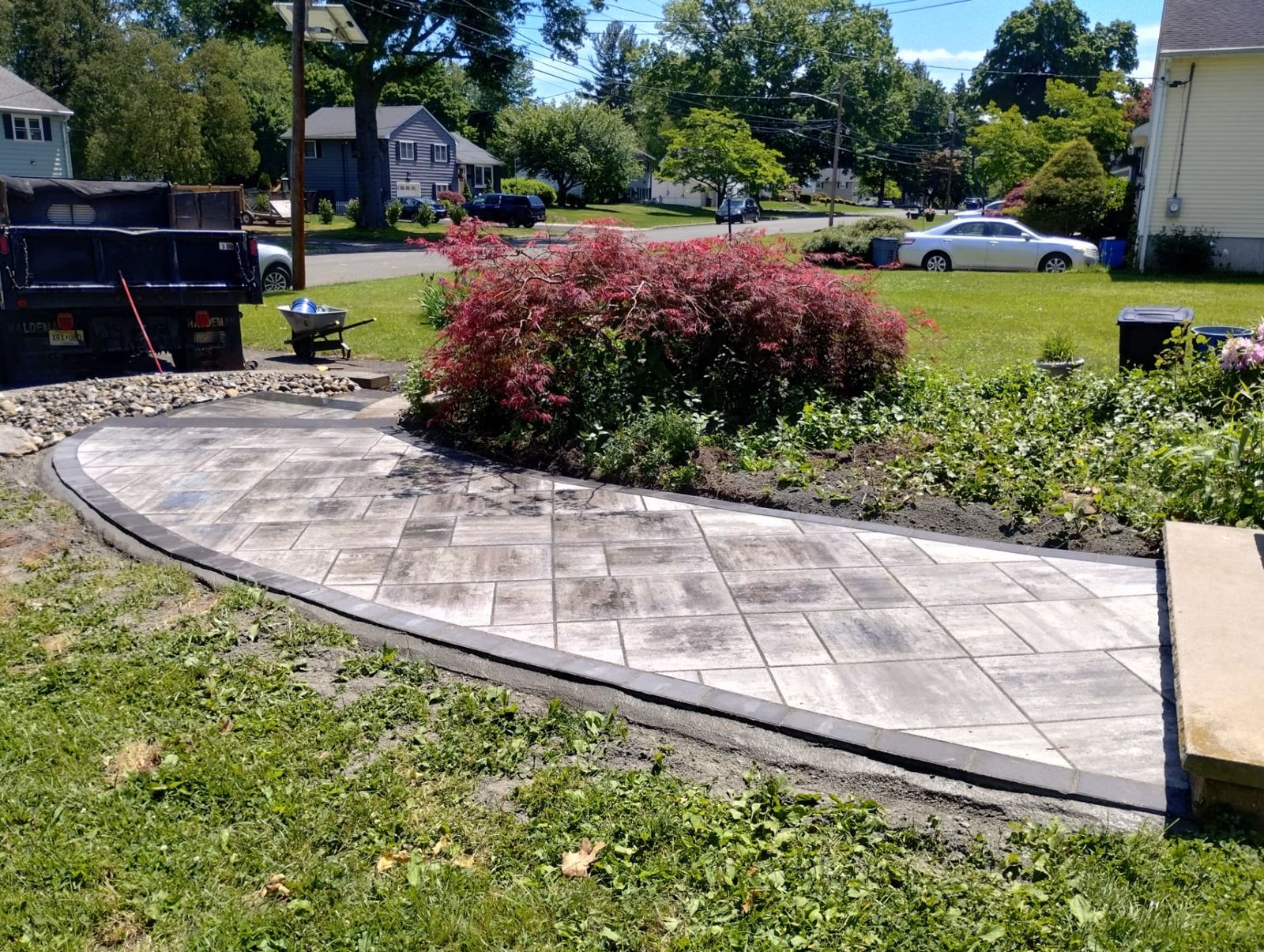 Front yard hardscape build with paver landing, steps and river rock beds in New Jersey
