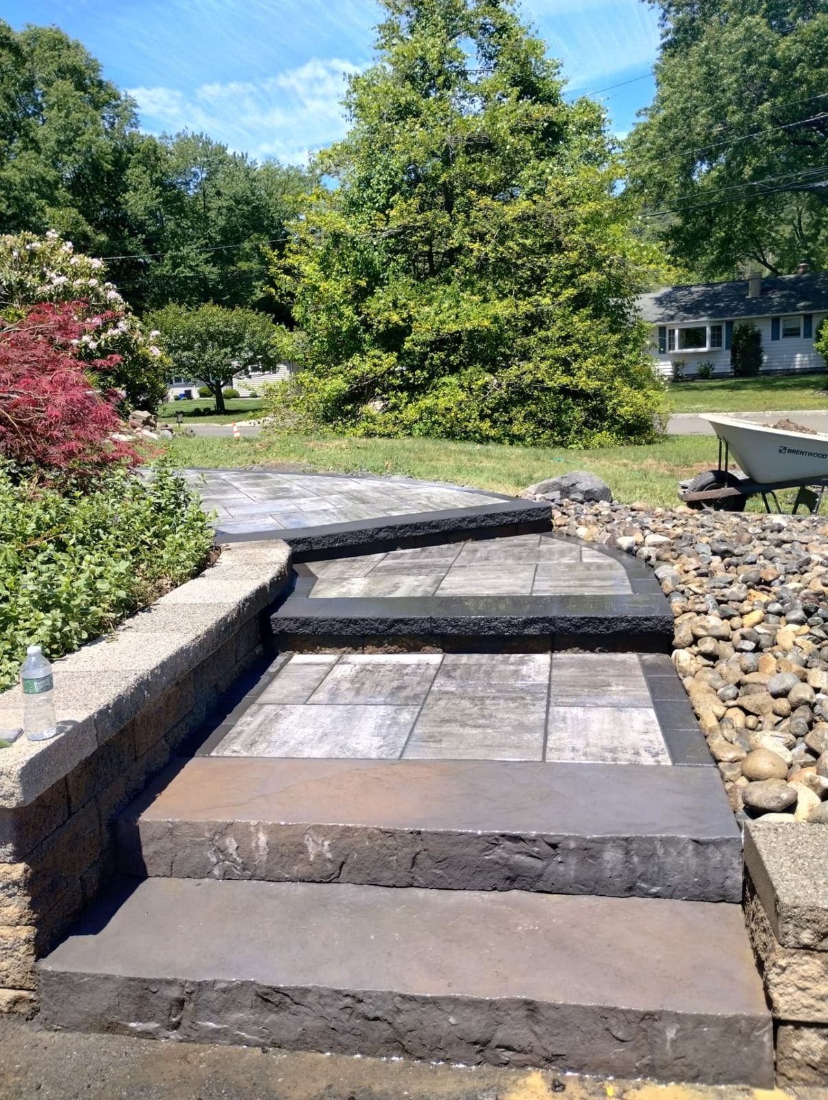 Front yard hardscape build with paver landing, steps and river rock beds in New Jersey
